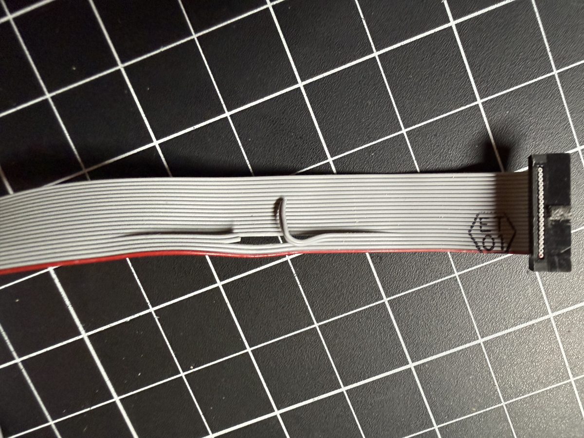 The 10-pin Silicon Labs Mini Simplicity ribbon cable used to reach J10